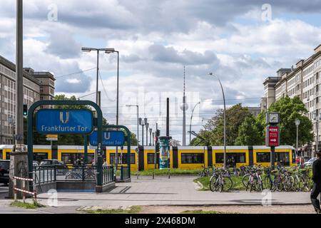 Ammira il viale Karl Mark Allee da Frankfurter Tor con un tram giallo di passaggio e la torre della televisione visibile in lontananza, Berlino, Germania, UE Foto Stock