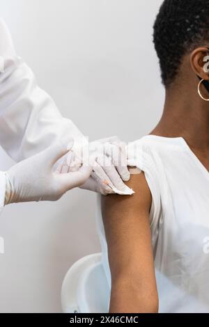 Primo piano della medica di coltura che fa l'iniezione per la paziente femmina nera Foto Stock