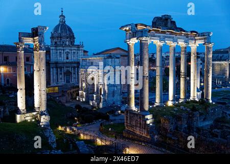 Foro Romano, Roma, Italia, al crepuscolo, con l'Arco di Settimio Severo e il Tempio di Vespasiano e Tito in primo piano Foto Stock