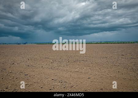 Nuvole di tempesta sul campo arato Foto Stock