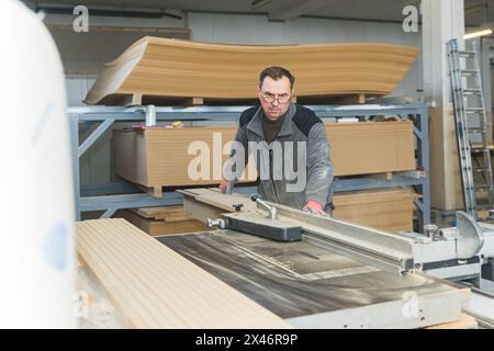 Falegname che lavora con attrezzature su un tavolo di legno in falegnameria. la donna lavora in una falegnameria. Foto di alta qualità Foto Stock