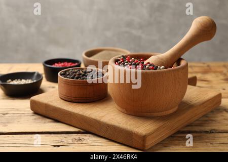 Diversi tipi di pepe aromatico sulla tavola di legno Foto Stock