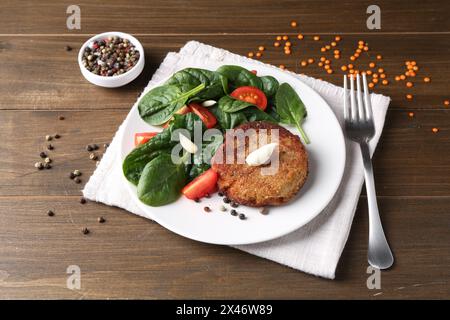 Gustosa cotoletta vegetariana servita con verdure su un tavolo di legno Foto Stock
