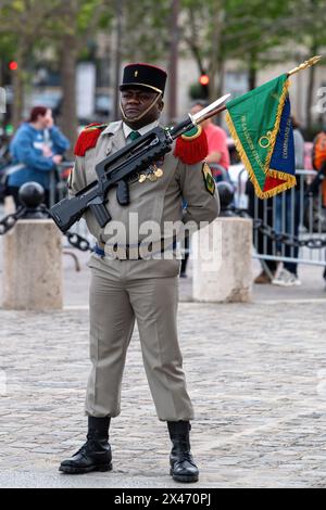 Un Sargent si trova a suo agio durante una cerimonia di rinascita amichevole per gli ex allievi delle unità della Legione straniera di Parigi e della Legione straniera all'Arco di Trionfo. Sullo sfondo dell'Arco di Trionfo, Parigi, ex allievi e unità della Legione straniera di Parigi tennero un incontro cerimoniale. Aderendo alla tradizione, l'evento onora l'eredità di servizio e sacrificio della Legione. I veterani e i membri attivi partecipano alle formalità, comprese le presentazioni delle bandiere e le cerimonie delle medaglie. L'evento sottolinea il significato storico dell'unità all'interno dell'esercito francese e commemora i suoi contributi duraturi. Foto Stock