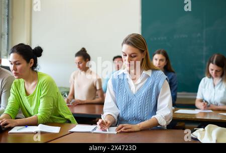 Ritratto di una studentessa adulta positiva durante la lezione in auditorium universitario Foto Stock