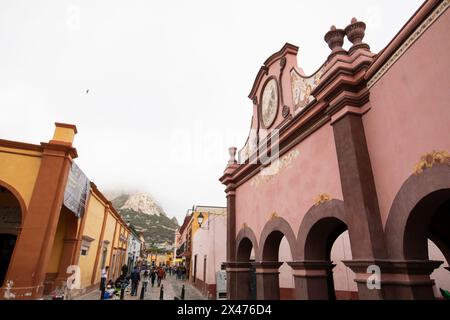 Bernal, Querétaro, Messico - 20 novembre 2023: I turisti passeggiano lungo gli edifici storici del centro storico di Bernal. Foto Stock