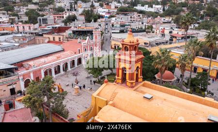 Bernal, Querétaro, Messico - 20 novembre 2023: I turisti passeggiano lungo gli edifici storici del centro storico di Bernal. Foto Stock