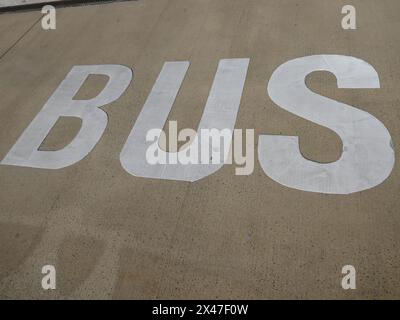 Cartellone del bus verniciato su fondo stradale asfaltato Foto Stock