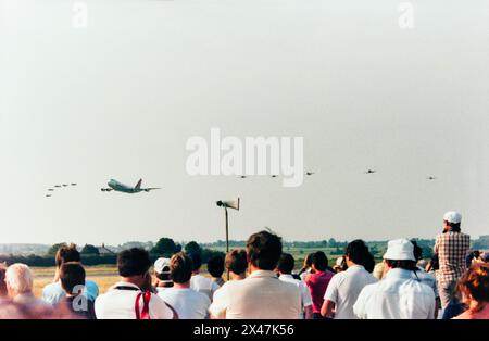 Northwest Orient Airlines Boeing 747 Jumbo Jet in volo in formazione con un gruppo di aerei da caccia della seconda guerra mondiale durante il North Weald Fighter Meet Airshow nel 1986. Un evento unico organizzato per celebrare il 60° anniversario della Northwest Orient Airlines. Gli aerei da combattimento della seconda guerra mondiale includevano uno Spitfire, Mustang, Thunderbolt e Corsair Foto Stock