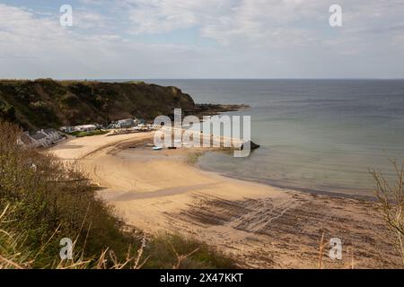 Il porto di Porth Nefyn e la spiaggia di Nefyn si vedevano dalla cima di una scogliera alla luce del sole serale. Nefyn è un villaggio situato sulla penisola di Llyn a North Wale Foto Stock