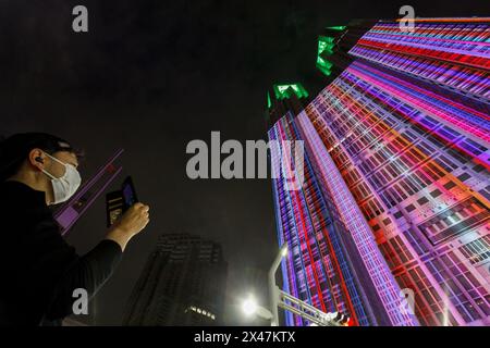 Tokyo, Giappone. 29 aprile 2024. Un uomo filma mentre guarda il progetto di mappatura della proiezione notturna e luminosa di Tokyo alla Tokyo Metropolitan Government Tower 1 a Shinjuku le esposizioni notturne del più grande progetto permanente di mappatura della proiezione del mondo iniziato nel febbraio 2024 e coprono circa 905 mq della facciata del simbolo di Tokyo. Uno spettacolo con Godzilla che attacca Tokyo è stato presentato il 27 aprile 2024. Credito: SOPA Images Limited/Alamy Live News Foto Stock