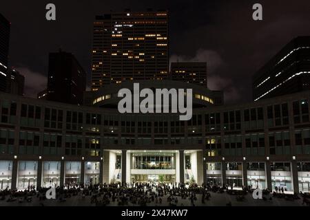 Tokyo, Giappone. 29 aprile 2024. La gente aspetta nella piazza di fronte per il progetto di mappatura della proiezione notturna e luminosa di Tokyo presso la Tokyo Metropolitan Government Tower 1 a Shinjuku. Le esposizioni serali del più grande progetto permanente di mappatura della proiezione del mondo sono iniziate nel febbraio 2024 e coprono circa 905 mq della facciata del simbolo di Tokyo. Uno spettacolo con Godzilla che attacca Tokyo è stato presentato il 27 aprile 2024. (Foto di Damon Coulter/SOPA Images/Sipa USA) credito: SIPA USA/Alamy Live News Foto Stock