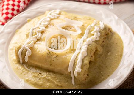 Cibo messicano. Enchiladas con salsa verde cremosa ripiena di carne di pollo grattugiata e ricoperta di formaggio fuso, in Messico si chiamano Swiss Enc Foto Stock