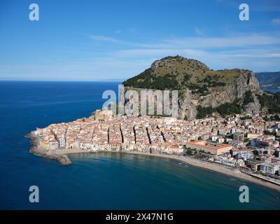 VISTA AEREA. Pittoresca cittadina balneare medievale di Cefalù sulla costa tirrenica. Provincia di Palermo, Sicilia, Italia. Foto Stock