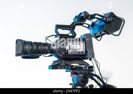 Vista laterale delle moderne telecamere di trasmissione 4K su un cavalletto. Grande videocamera montata su supporti in occasione di una conferenza o di un evento video professionale in diretta streaming Foto Stock