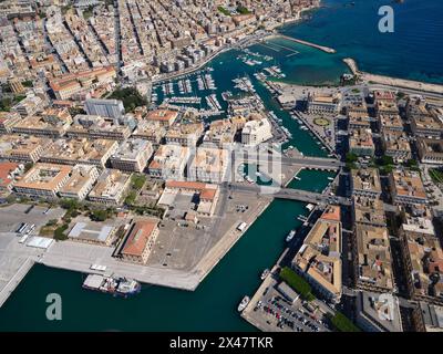 VISTA AEREA. Porto piccolo, un porto turistico tra Siracusa (a sinistra del canale) e l'isola di Ortigia (a destra del canale). Provincia di Siracusa, Sicilia, Italia. Foto Stock