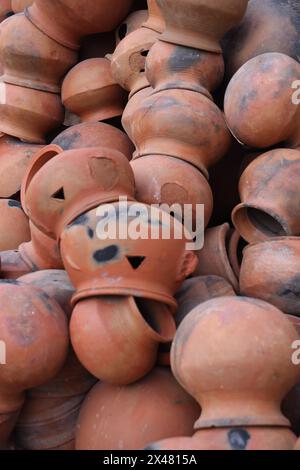 le pentole sono raccolte e disposte in uno schema nello spazio vuoto. Il vasaio lavora su una ruota di ceramica realizzata in argilla dai colori tenui, in stile retrò con tonalità Cl Foto Stock