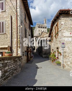 Gubbio, Italia - 27 aprile 2024: Via nel centro storico. Sullo sfondo, il Palazzo dei Consoli. Foto Stock