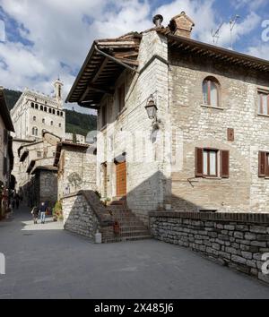 Gubbio, Italia - 27 aprile 2024: Casa nel centro storico. Sullo sfondo, il Palazzo dei Consoli. Foto Stock