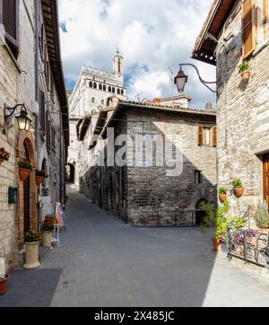 Gubbio, Italia - 27 aprile 2024: Via nel centro storico. Sullo sfondo, il Palazzo dei Consoli. Foto Stock