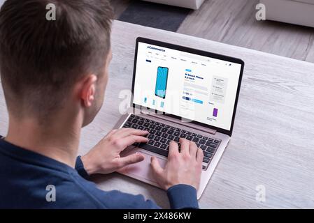 Acquisto di smartphone online con notebook. Concetto di acquisto di dispositivi tecnologici online, che illustra la praticità e la facilità di acquisto digitale per l'elettronica Foto Stock
