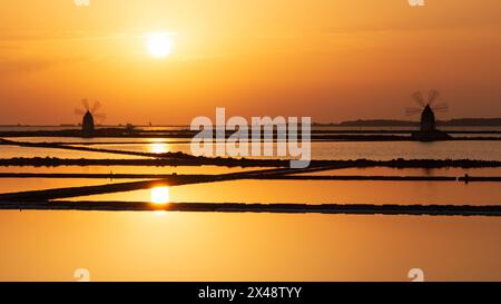 Splendido tramonto sulle saline di Mozia con gli storici mulini a vento Foto Stock