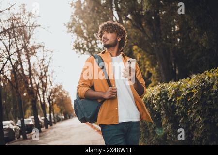 Ritratto di un giovane e attraente uomo indiano che viaggia in città esplorando nuovi luoghi utilizzando la navigazione gps vacanze estive all'aperto Foto Stock