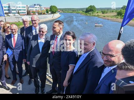 1° maggio 2024, Brandeburgo, Francoforte (Oder): Dietmar Woidke (3° da sinistra), Ministro Presidente del Brandeburgo.r, SPD), Ministro Presidente del Brandeburgo, Joschka Fischer (Alleanza 90/Verdi), ex Ministro degli Esteri federale, Radoslaw Sikorski, Ministro degli Esteri polacco, Annalena Baerbock (Alleanza 90/Verdi), Ministro federale degli Esteri, Wlodzimierz Cimoszewicz l'ex ministro degli Esteri polacco e Rene Wilke (sinistra), sindaco di Francoforte (Oder), si presentano in occasione del ventesimo anniversario dell'adesione della Polonia all'UE. Si trovano sul ponte cittadino tra le città gemelle di Francoforte (Oder) Foto Stock