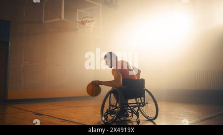 Il giocatore di pallacanestro su sedia a rotelle che indossa l'uniforme rossa porta la palla a segnare un gol perfetto. Determinazione, formazione, ispirazione di una persona con disabilità. Grandangolo con colori caldi Foto Stock