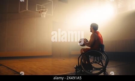 Giocatore di pallacanestro su sedia a rotelle che indossa una palla rossa, pre-abbinamento per segnare un gol perfetto. Determinazione, formazione, ispirazione di una persona con disabilità. Grandangolo con colori caldi Foto Stock