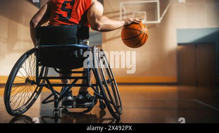 Giocatore di pallacanestro in sedia a rotelle che indossa una palla Dribbling rossa come un professionista. Determinazione, motivazione di una persona con disabilità che eccelle al Team Sport. Anonimo, immagine retrovisiva Foto Stock