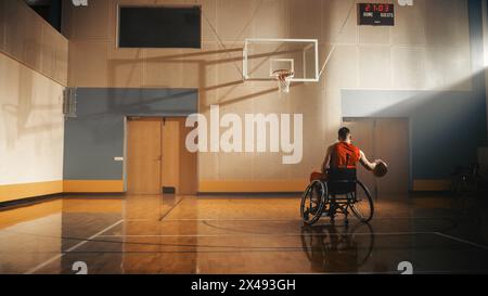 Giocatore di pallacanestro in sedia a rotelle che indossa una palla Dribbling rossa come un professionista. Determinazione, motivazione di una persona con disabilità che eccelle al Team Sport. Anonimo, immagine retrovisiva Foto Stock