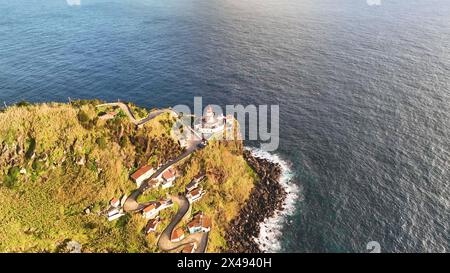 Veduta aerea dell'incredibile faro Farol Ponta do Arnel nell'oceano atlantico, riprese in 4K. Sao Miguel, Azzorre, Portogallo. Foto Stock