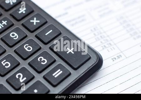 Primo piano di una calcolatrice, di un dispositivo di input periferico, sopra un foglio di carta, di un'apparecchiatura da ufficio spesso utilizzata con una tastiera per computer o un personal com Foto Stock