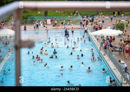 01 maggio 2024, Renania settentrionale-Vestfalia, Essen: Piscina completa a temperature estive di circa 28 gradi. Migliaia di persone visitano il Grugabad ad Essen il 1° maggio soleggiato a temperature di 28 gradi. Numerose piscine all'aperto iniziano la stagione. Foto: Christoph Reichwein/dpa Foto Stock
