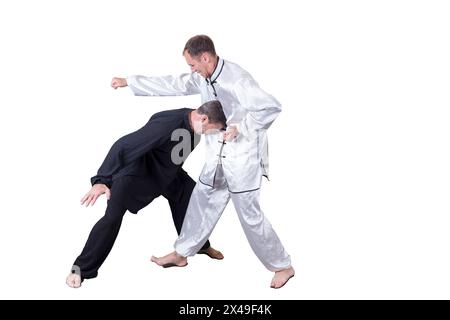 L'atleta adulto esegue esercizi formali di goju-ryu. È isolato su uno sfondo bianco. Primo piano. Foto Stock