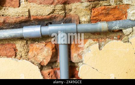 Tubazioni tradizionali che utilizzano il montaggio di tubi di scarico. Tubazioni per pareti in mattoni Foto Stock