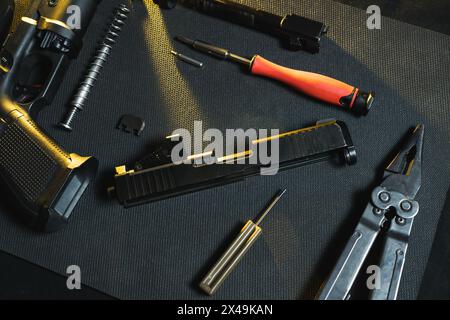 Sparare, pulire e riparare le armi. Pistola smontata in officina. Foto Stock