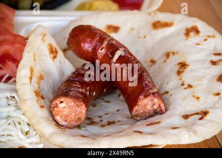 Tortilla wrap, una deliziosa fusione di salumi salati, patatine fritte croccanti, insalata verde fresca, pomodori succosi, cipolle saporite, e il cavolo tagliato Foto Stock
