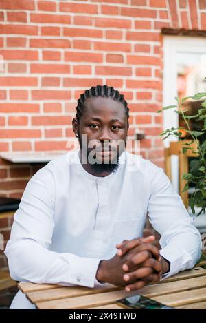Allegro abito turistico maschile in bianco indossa un sorriso etnico dashiki al City Street Cafe. Il modello di viaggio afroamericano ha tempo libero Foto Stock