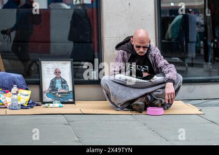 LONDRA - 4 APRILE 2024: Un senzatetto con un gatto in Oxford Street nel West End Foto Stock