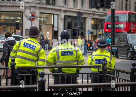 LONDRA - 4 APRILE 2024: Tre agenti di polizia incontrarono di pattuglia su Oxford Street Regent Street Foto Stock