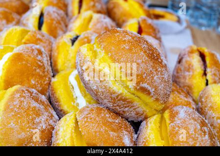 Pasticceria con palle di Berlino ripiene con panna o marmellata di frutta in vendita sul mercato alimentare Foto Stock