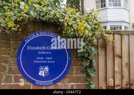 Targa blu a Elizabeth Gaskell autrice di casa che possedeva nel villaggio di Holybourne vicino ad Alton, Hampshire, Inghilterra, Regno Unito Foto Stock