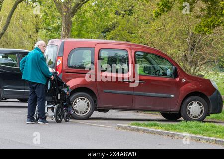 Uomo anziano che si prende cura della moglie disabile su una sedia a rotelle, Inghilterra, Regno Unito. Concetto: Assistenti non retribuiti, assistenza inadeguata per anziani e disabili Foto Stock