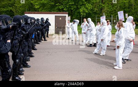 EFT Hellendorf, Germania. 1° maggio 2024. Le forze di polizia di Kirkel formano una linea difensiva con attrezzature protettive, caschi e bastoni come parte dell'esercizio di sicurezza nazionale del National Guardian 2024. L'esercizio prevede la messa in sicurezza e la protezione di un centro di approvvigionamento di munizioni. Durante l'esercitazione della National Guardian Bundeswehr, le forze di sicurezza nazionale in tutta la Germania praticano la loro missione principale di proteggere e garantire infrastrutture di difesa vitali. Credito: Laszlo Pinter/dpa/Alamy Live News Foto Stock