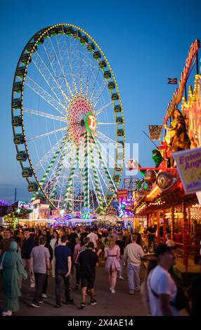 Stoccarda, Germania. 1° maggio 2024. All'ora blu, numerose persone attraversano il Cannstatter Wasen e visitano il 84° Festival primaverile di Stoccarda. Crediti: Christoph Schmidt/dpa/Alamy Live News Foto Stock