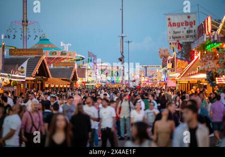 Stoccarda, Germania. 1° maggio 2024. All'ora blu, numerose persone attraversano il Cannstatter Wasen e visitano il 84° Festival primaverile di Stoccarda. Crediti: Christoph Schmidt/dpa/Alamy Live News Foto Stock