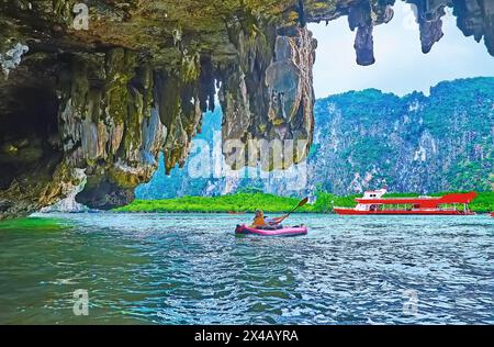 Le rocce, le mangrovie e la grande nave turistica dietro le stalattiti nella grotta di Ko Thalu OK Island, Phang Nga Bay, Thailandia Foto Stock