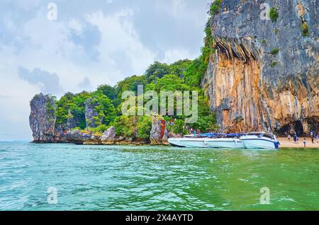 La costa rocciosa dell'isola di James Bond con una piccola spiaggia, che funge da porto per le barche turistiche, in Thailandia Foto Stock